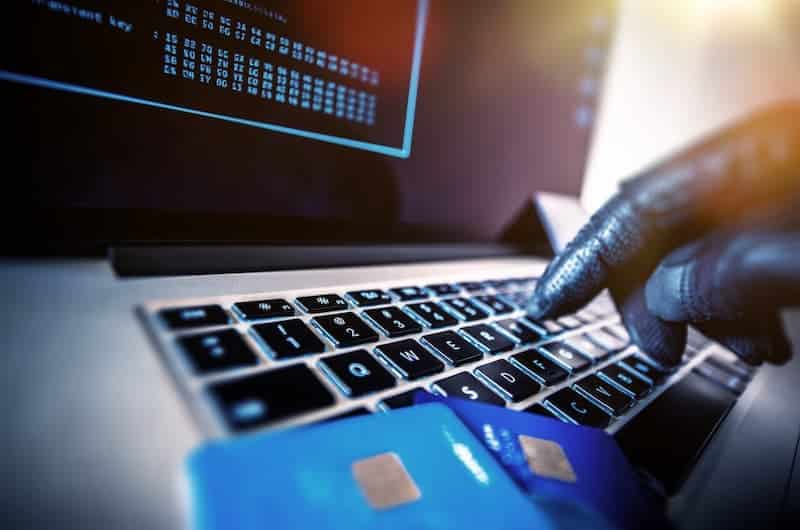 cyber security related image - laptop, banking cards, and a hand with glove