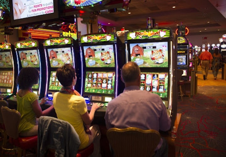 3 people playing slot machines.